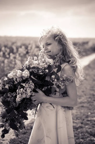 Charmant enfant caucasien avec bouquet lilas aux mains monochrome — Photo