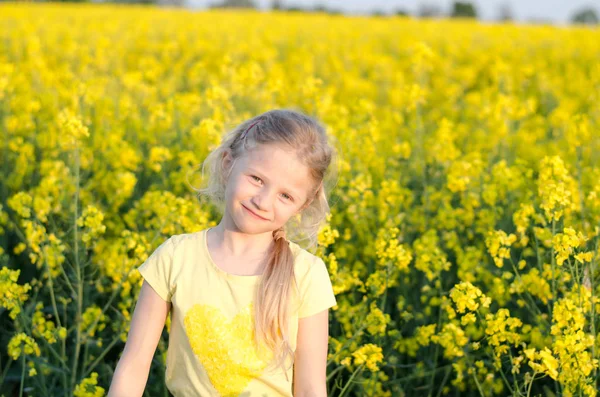 Encantadora menina loira relaxante no prado amarelo — Fotografia de Stock