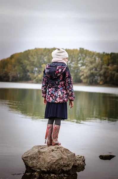 Linda menina de pé ao lado da lagoa vista traseira — Fotografia de Stock