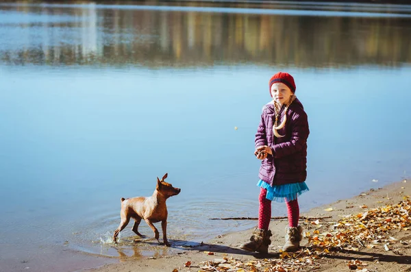 Kind en hond bij het meer — Stockfoto