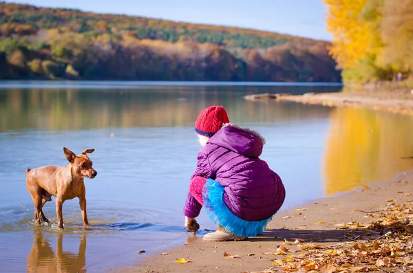 Kind en hond in de wandeling bij het meer — Stockfoto