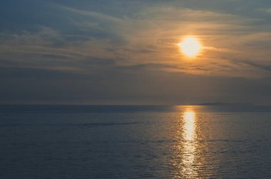 Mavi deniz ufkunda renkli turuncu gün batımı