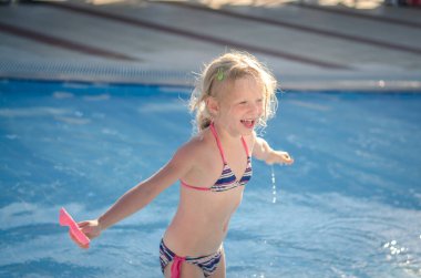 Sevimli çocuk yaz tatilinde havuzda yüzerken eğleniyor.