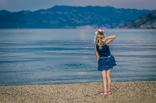 Visão Traseira Menina Vestido Colorido Jogando Seixos Mar Azul Escuro — Fotografia de Stock