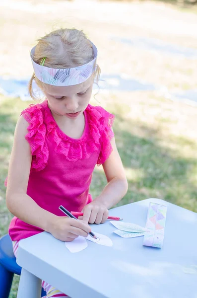 かわいい女の子が屋外に座って鉛筆で着色 — ストック写真