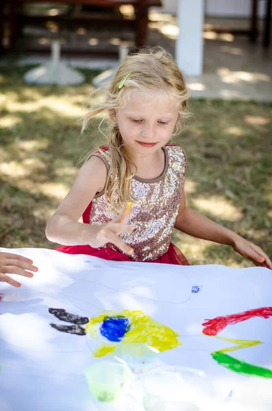 明るい色と指で創造的なブロンドの女の子の絵 — ストック写真