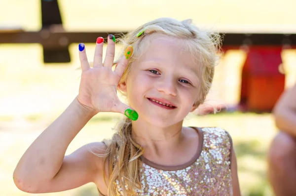 明るい色で描かれた指を示す小さな女の子 — ストック写真
