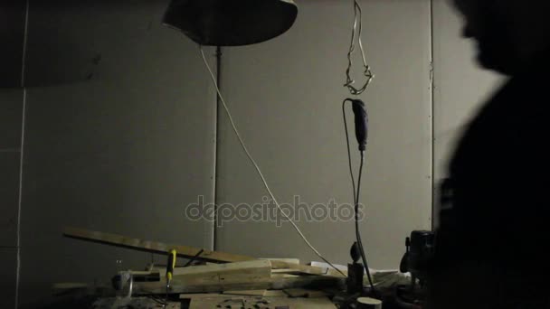 Жирний майстер готується до роботи, вмикаючи світло у своїй майстерні — стокове відео
