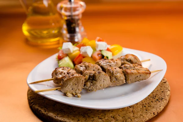 Şiş kebap sebzeli bir tabakta servis edilir.