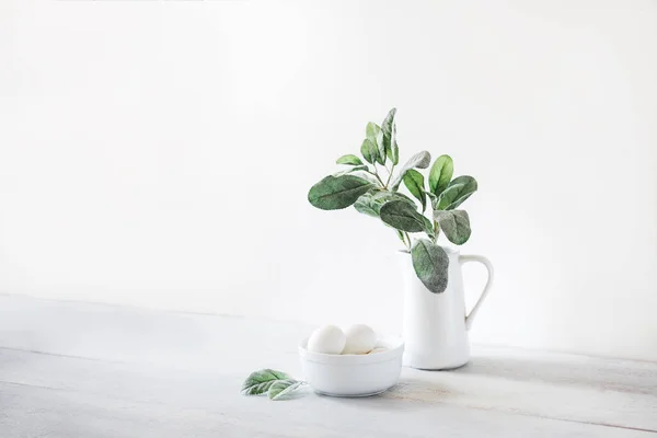 Kendi putih dengan tanaman bijak, mangkuk putih dengan telur di backgro putih — Stok Foto
