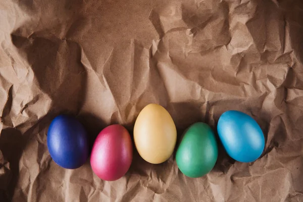 Colorful Easter eggs on brown wrinkled paper