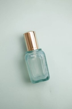 Yüz kremli yüz serumu şişesi, açık deniz mavisi kapsülleri. Kozmetik düzlüğü.