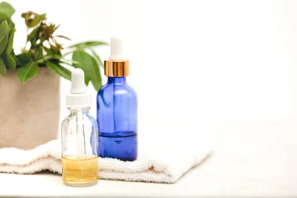 Beyaz zemin üzerinde cilt bakım ürünleri olan renkli cam şişeler. Ruhsal yağlar için yüz serumları, asitler ve paketler.