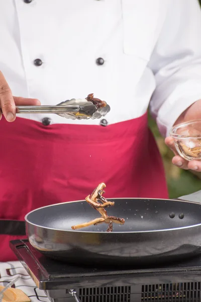 Шеф-повар клал грибы на сковородку — стоковое фото