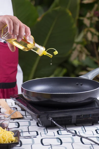 Chef derramando óleo vegetal para a panela — Fotografia de Stock