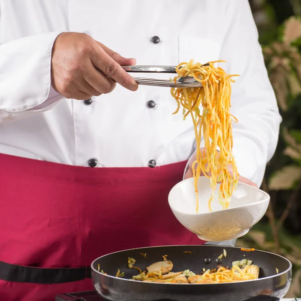 Chef fork over noodles by tongs — Stock Photo, Image