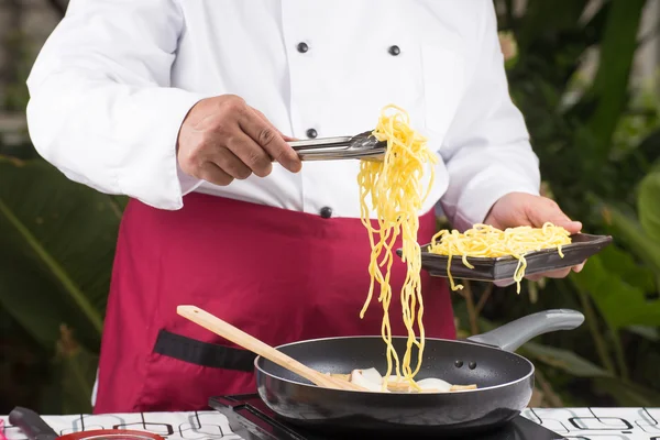 トングでシェフ入れて麺 — ストック写真