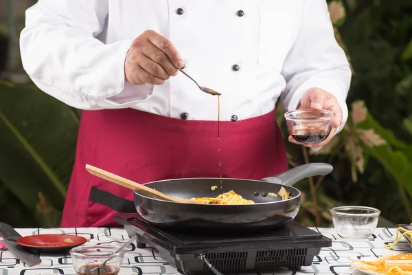 Chef putting soy sauce for cooking / — 图库照片