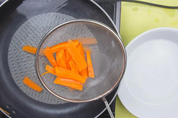 Chef scald carrot with hot water — Stock Photo, Image