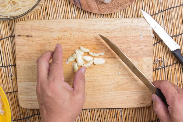 Kocken skivning vitlök med kniv — Stockfoto