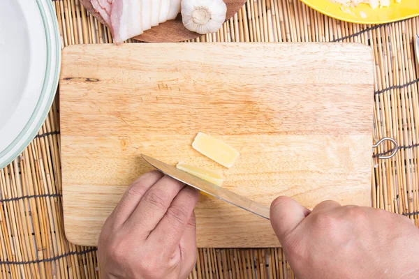 Chef coupe fromage avec couteau avant cuisson — Photo