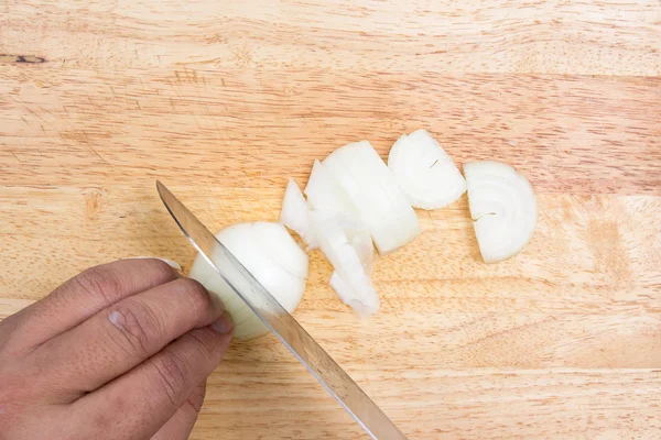 Chef slicing onion on wooden broad — Stock Photo, Image