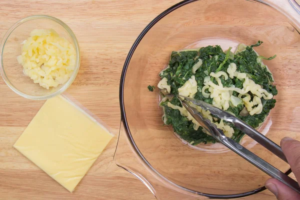 Положить сыр в миску для шпината — стоковое фото