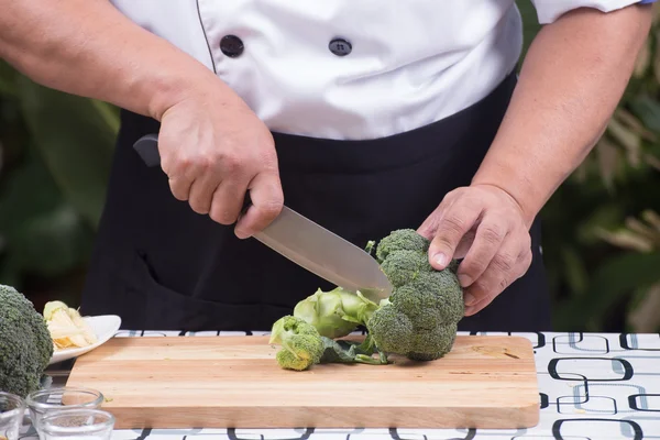 Шеф-повар режет брокколи для приготовления пищи — стоковое фото