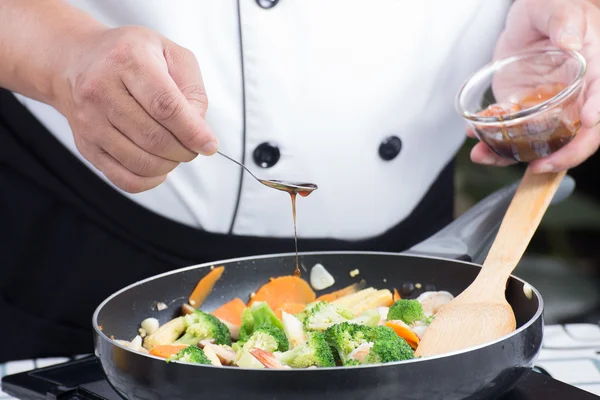 Chef poniendo salsa de ostras para cocinar — Foto de Stock