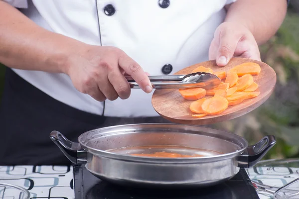 Koch setzt Karotte zum Kochen ein — Stockfoto