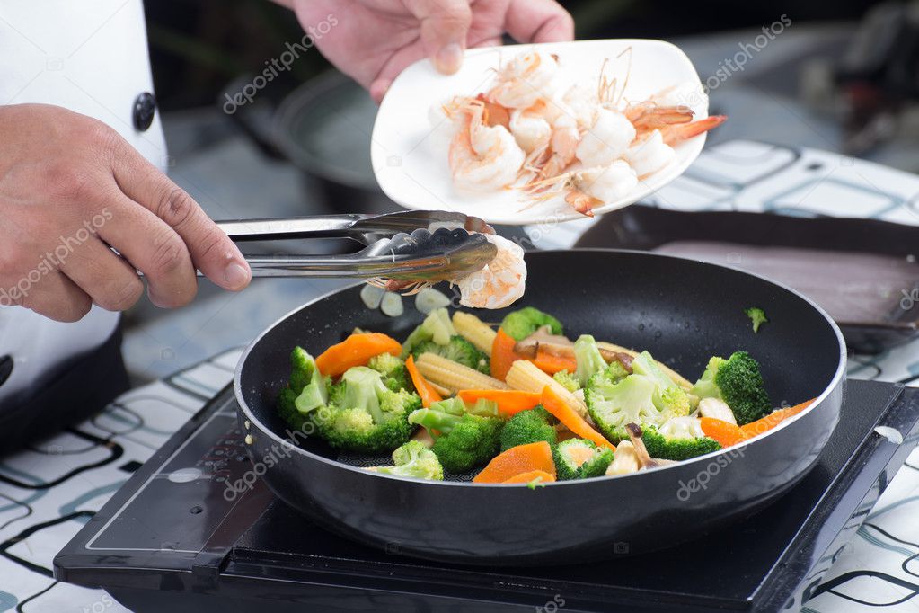 Chef putting shrimp to pan 