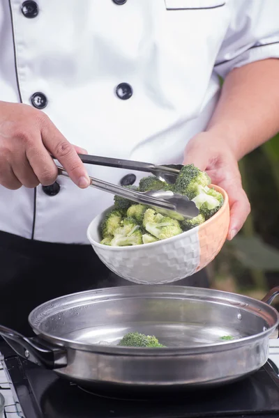 Chef colocando brócolis água quente com pinças — Fotografia de Stock