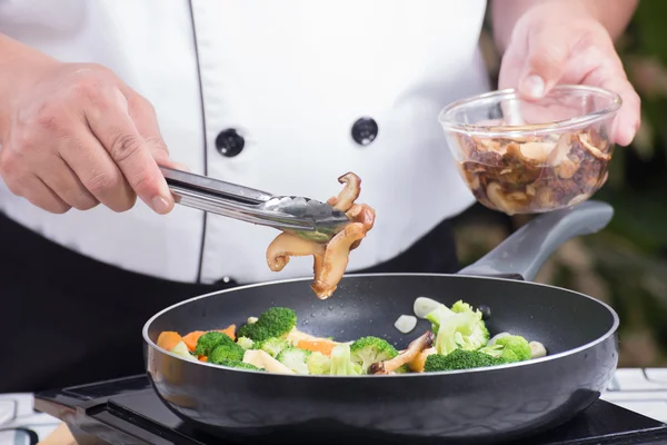 Chef-kok zetten paddestoel pannen — Stockfoto