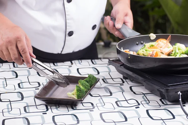 Koch dekoriert braten Gemüse auf Teller — Stockfoto