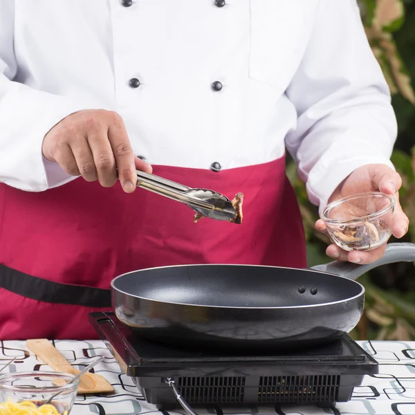 Chef colocando cogumelo na panela — Fotografia de Stock