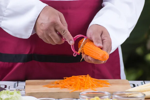 Chef cortando cenouras com descascador — Fotografia de Stock