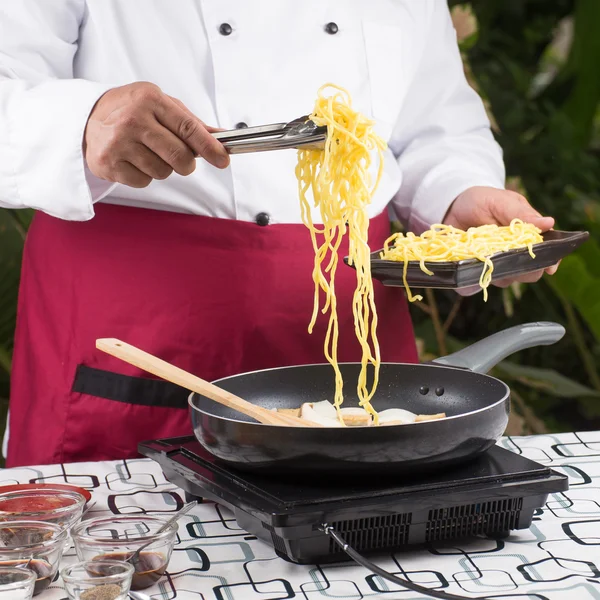 Chef colocando macarrão com pinças — Fotografia de Stock