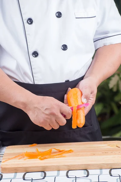 Шеф чистит морковь. — стоковое фото