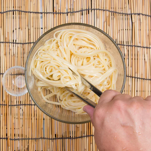 Cooking oil to Spaghetti with tongs — Stock Photo, Image