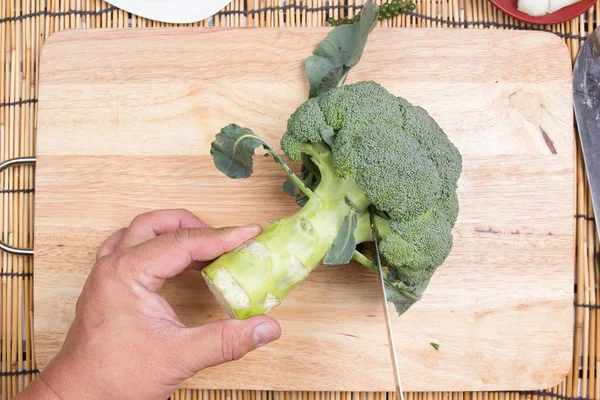 Chef cutting broccoli before cooking with knife — Stock Photo, Image