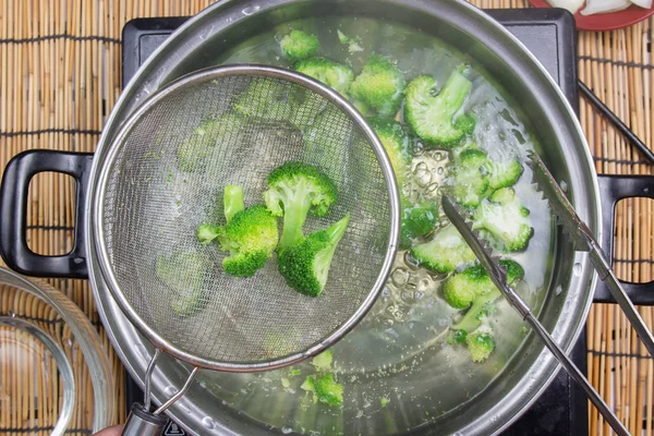 Шеф-повар варит брокколи на сковороде — стоковое фото