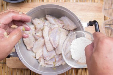 Yemek pişirmek için tavuk kanadı için un koyarak Şef