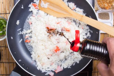 Şef soya sosu pilav yemek pişirmek için koyarak 