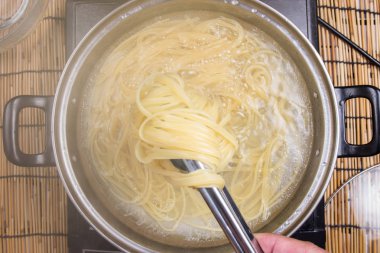 Maşa ile haşlanmış makarna elinde Şef 