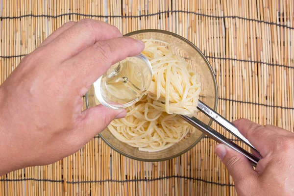 Aceite de cocina para espaguetis con pinzas — Foto de Stock
