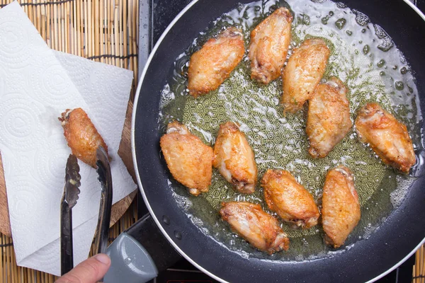 Chef fritando asas de frango na panela — Fotografia de Stock