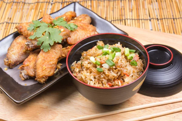 Fried chicken wings served with fry rice