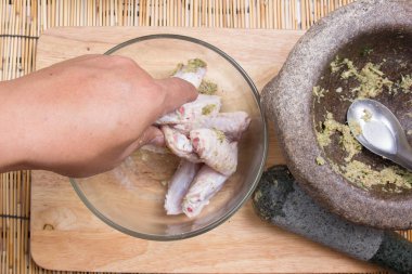 Şef yemek pişirmek için tavuk kanadı için baharat karıştırma