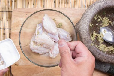 Şef puttinfg tuz yemek pişirmek için tavuk kanadı için