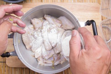 Yemek pişirmek için tavuk kanadı için un koyarak Şef